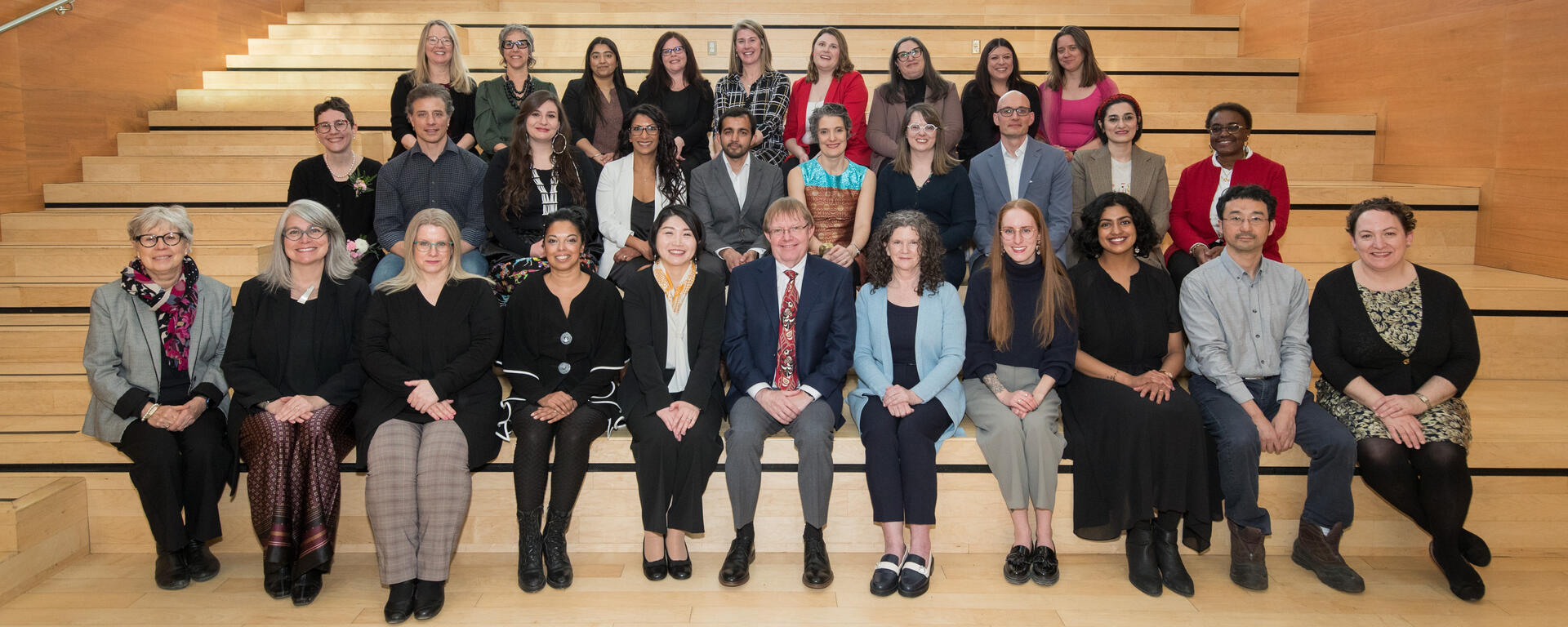 The 2024 Teaching Award winners sitting on the stairs at the Taylor Institute for Teaching and Learning.