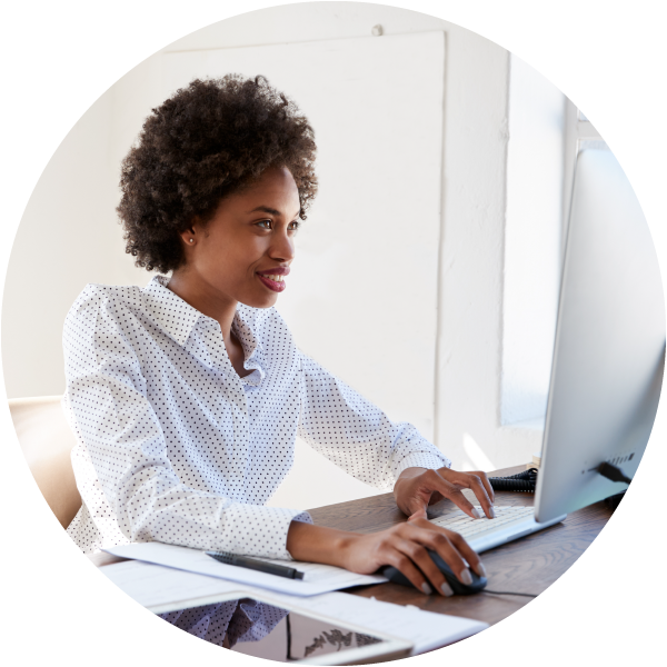 Black female sitting at a desk working on a computer